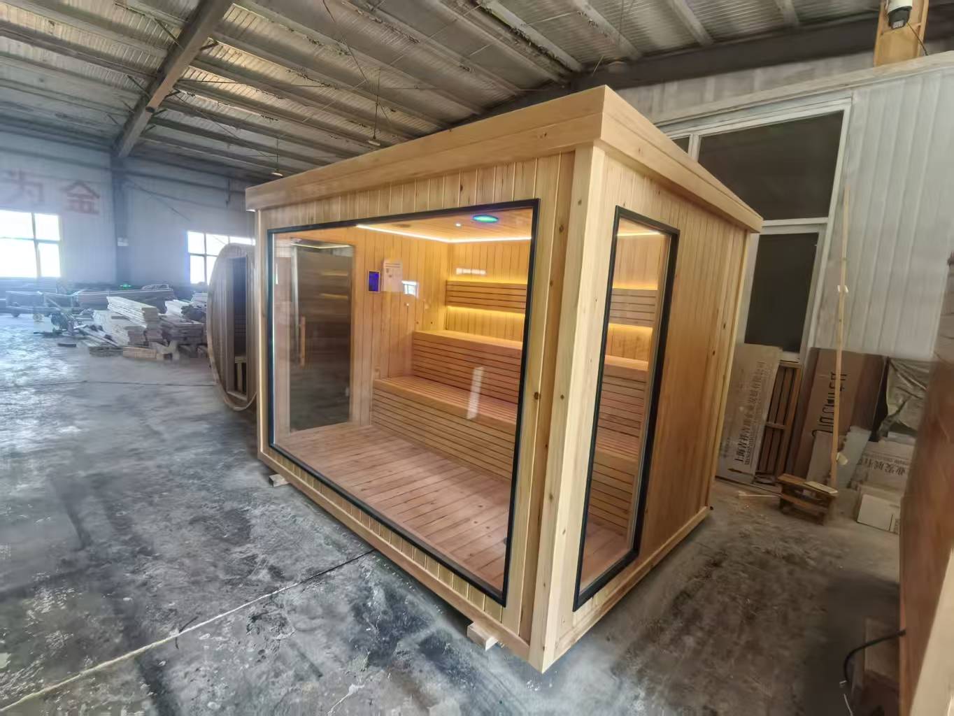 Luxurious 6 - person outdoor black square - shaped sauna. Made of spruce, in a cube shape, equipped with a 6KW heater and LED lights, suitable for use in an outdoor spa.