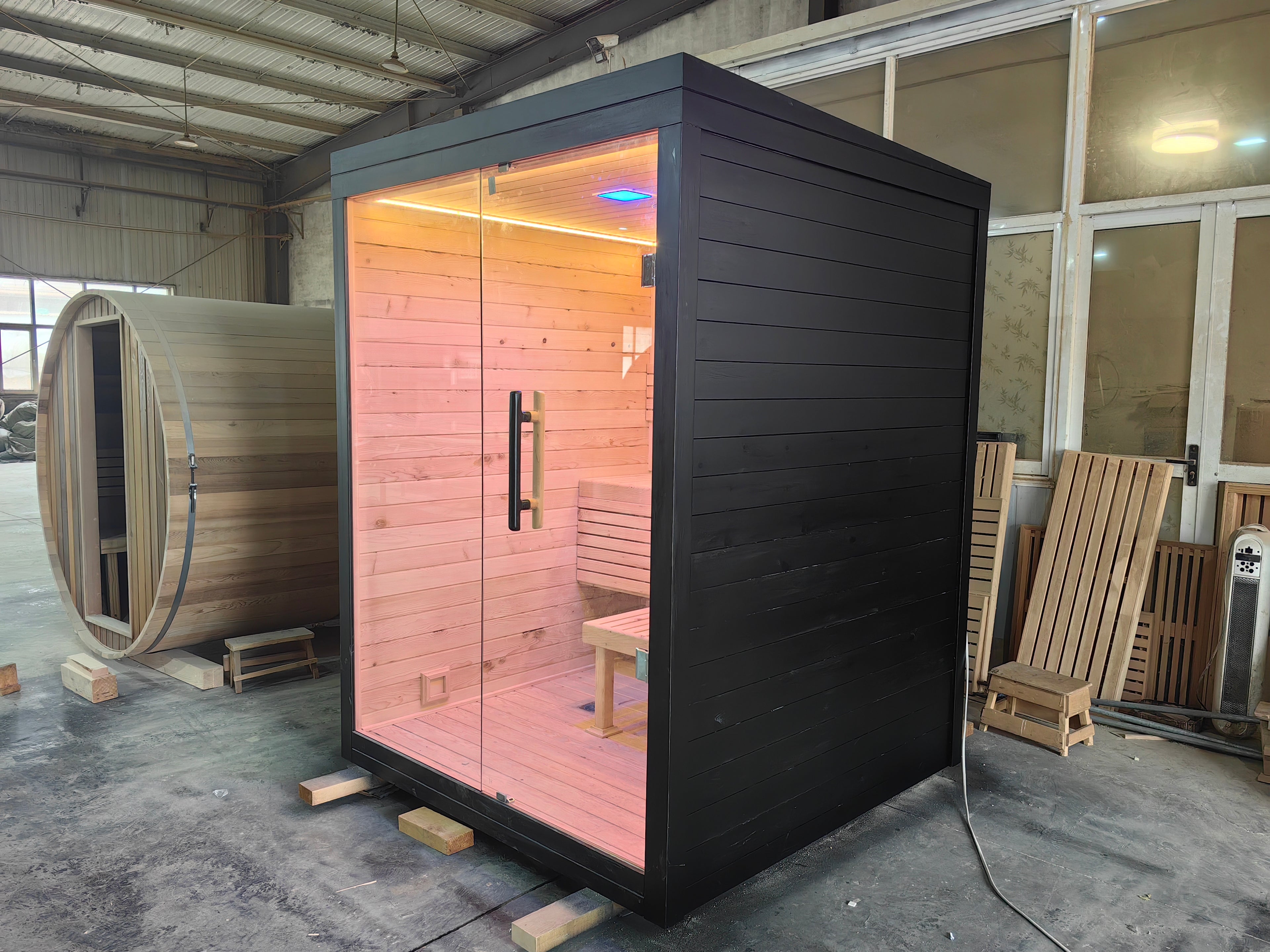 A modern indoor solid - wood sauna suite in a square - shaped room suitable for 2 - 4 people, equipped with an electric furnace and a control panel.
