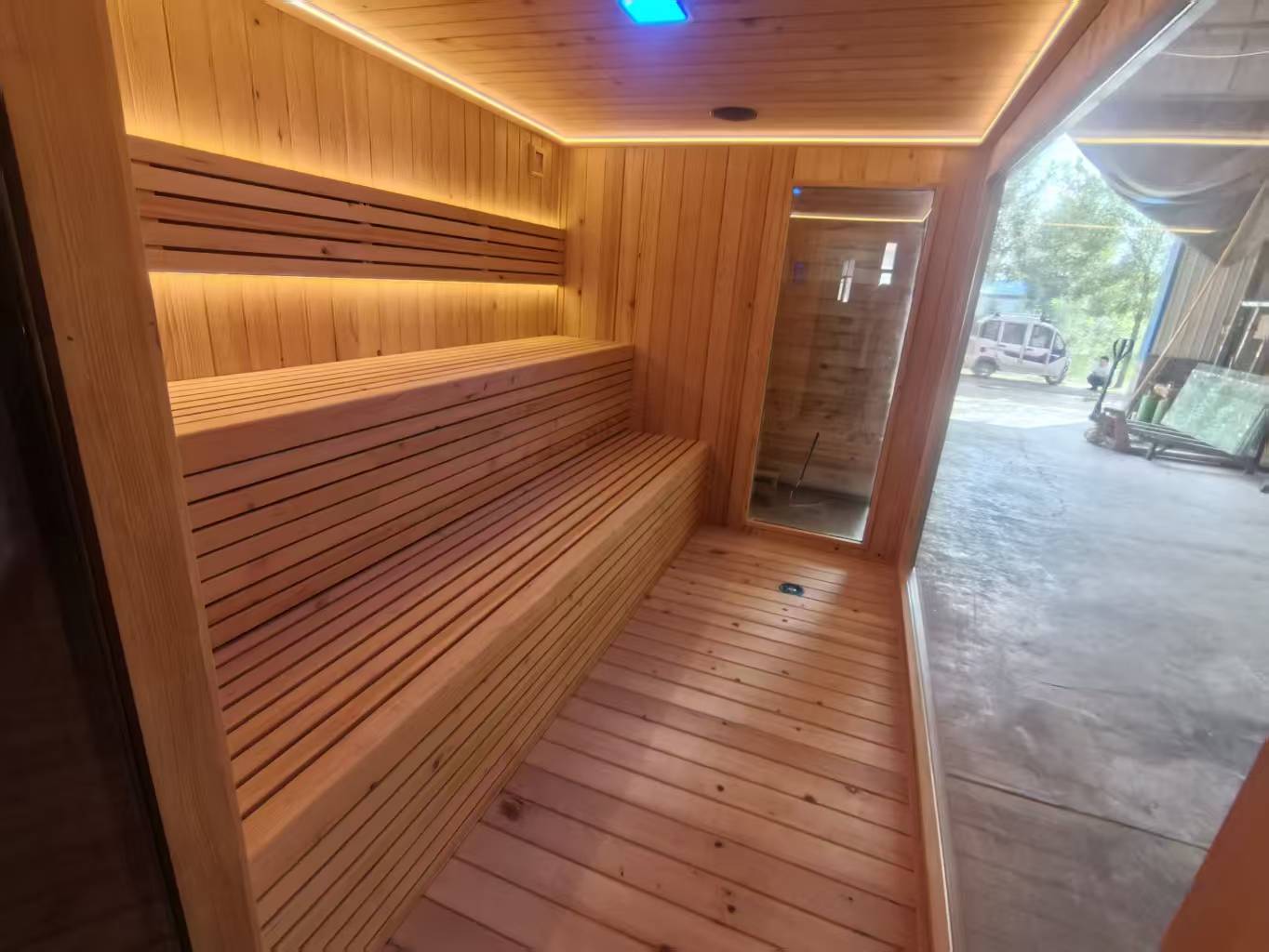 Luxurious 6 - person outdoor black square - shaped sauna. Made of spruce, in a cube shape, equipped with a 6KW heater and LED lights, suitable for use in an outdoor spa.