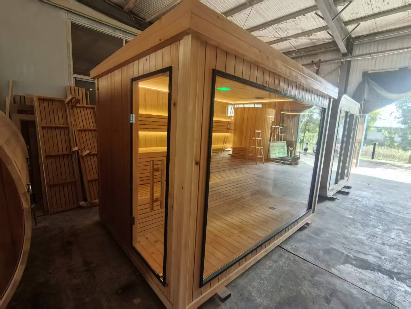 Luxurious 6 - person outdoor black square - shaped sauna. Made of spruce, in a cube shape, equipped with a 6KW heater and LED lights, suitable for use in an outdoor spa.
