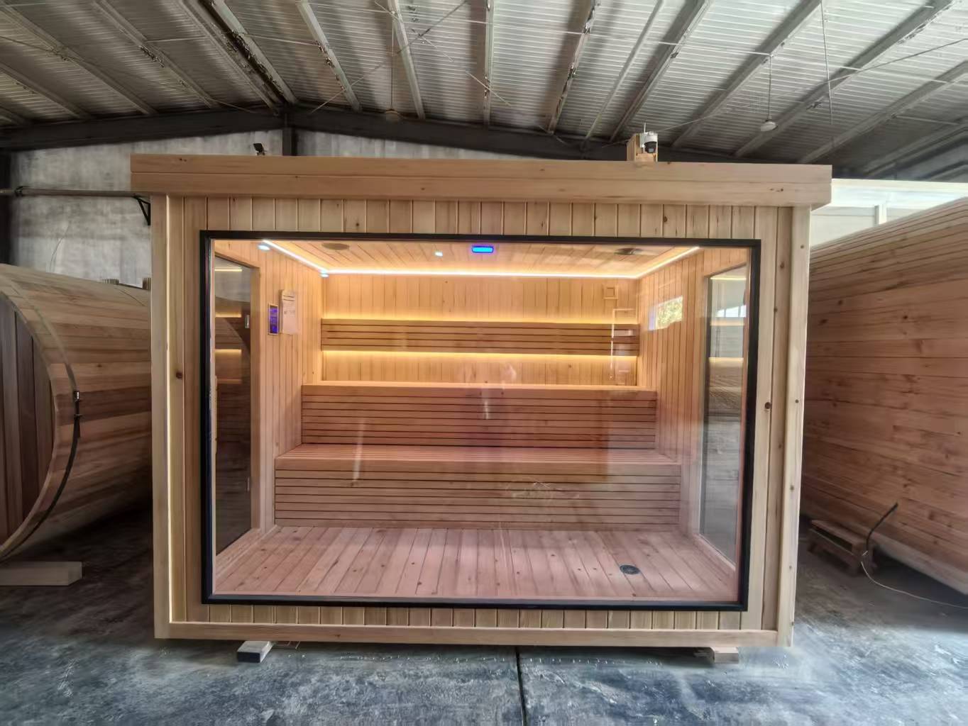 Luxurious 6 - person outdoor black square - shaped sauna. Made of spruce, in a cube shape, equipped with a 6KW heater and LED lights, suitable for use in an outdoor spa.